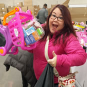 Our vice president, a woman, smiling, holding some children's toys, and giving a thumbs up.
